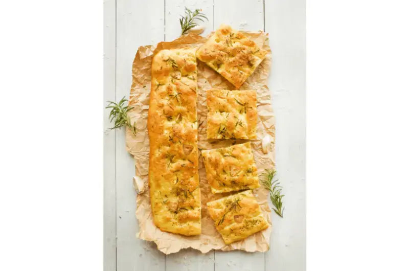 Sourdough Ligurian focaccia baked in a sheet pan, dimpled top glistening with olive oil and flaky sea salt