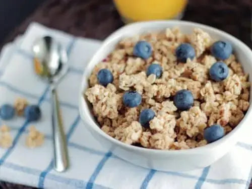 A bowl of morning hot cereal topped with sliced banana, berries, nuts and seeds