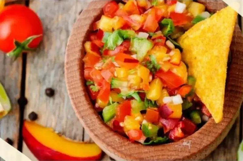 Fresh peach salsa with tomatoes, peaches, cilantro and lime in a bowl