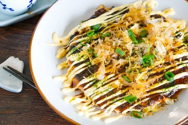 Japanese okonomiyaki savory cabbage pancake topped with sauce, mayonnaise and bonito flakes