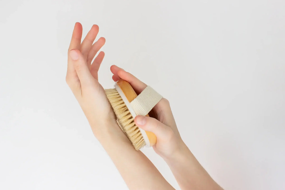 Natural bristle dry brush resting on a folded towel in a bathroom